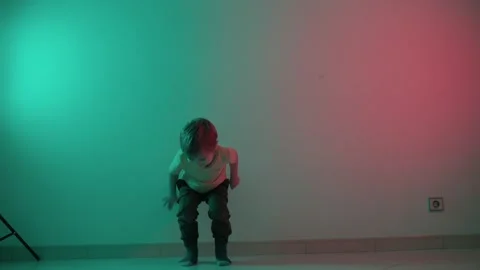 Young boy dancing with teal and red lighting Stock Footage 316168865