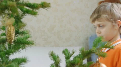 Young boy decorates a Christmas tree Stock Footage 19041819