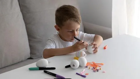 Young Boy Decorating White Easter Egg with Marker 写真素材