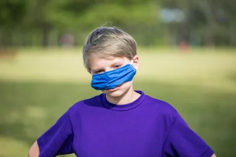 Young boy demonstrating the wrong way to wear a face mask, shows frustration. Stock Photos