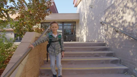 A Young Boy Descending the Stairs with a Backpack on His Back at School Video stock 305434472