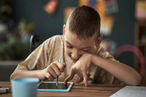 Young Boy with Disability Engaging With Digital Tablet for Learning Stock Photos