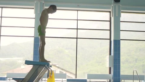 Young boy diving into the swimming pool. Child jumps into the water Stock Footage 157722669