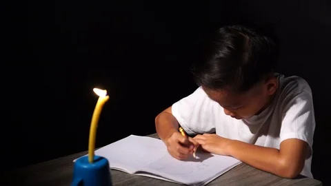 Young boy do home work under candle light Vidéo 94466784
