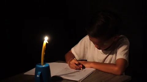 Young boy do home work under candle light Stock Footage 96385505