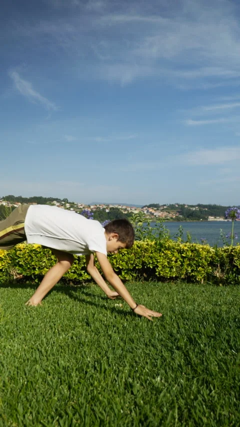 Young boy doing a handstand in the garden Stock Footage 211048776