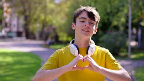 Young boy doing heart shape with hands Stock Footage 252875866