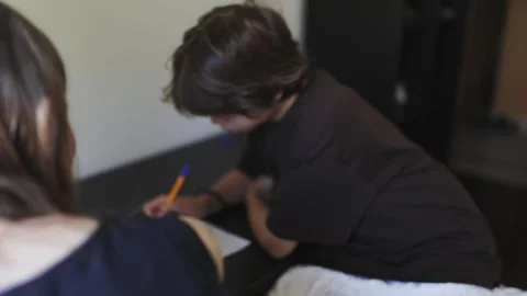 Young boy doing homework, writing on paper at home Stock Footage 311502677