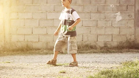 Young boy doing kick with ball on natural street Stock Footage 49032457