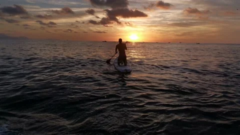 Young boy doing paddle surf at sunset Stock Footage 135745203