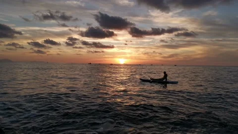 Young boy doing paddle surf at sunset Stock Footage 135745317