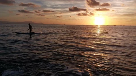 Young boy doing paddle surf at sunset Stock Footage 135745375