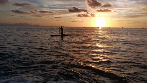 Young boy doing paddle surf at sunset Stock Footage 135745687