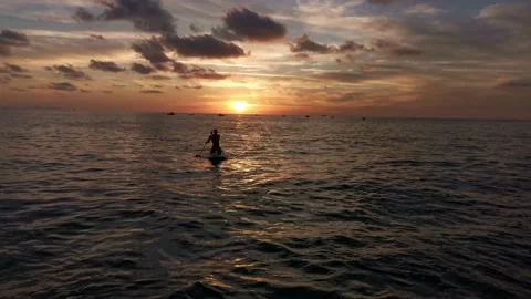 Young boy doing paddle surf at sunset Stock Footage 135745957