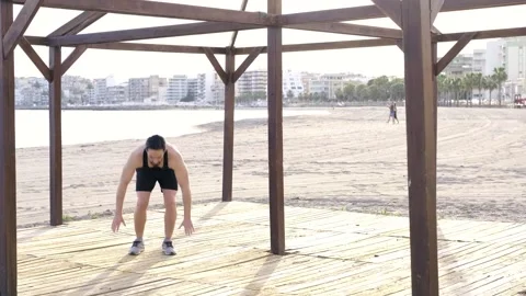 Young boy doing physical exercise at the beach Stock Footage 131006674
