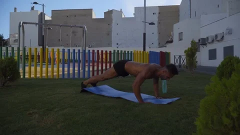 A young boy is doing push up exercises in the street. Calisthenic Stock Footage 250935295