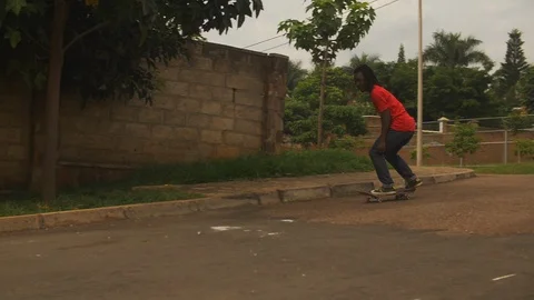 Young boy doing tricks on skateboard in the street slow motion Видео 113000293