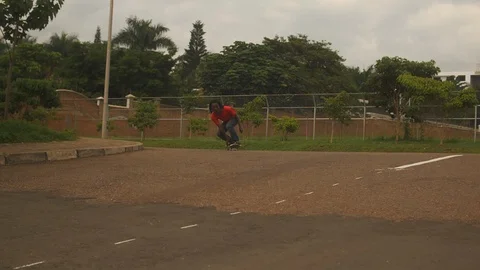 Young boy doing tricks on skateboard in the street in slow motion Stock Footage 113000981
