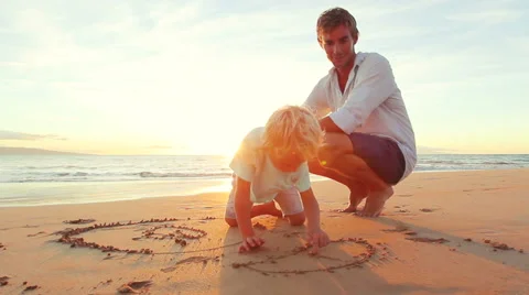 Young Boy Drawing in the Sand at the Beach at Sunset. Father Son Playing Toge Stock Footage 56531597