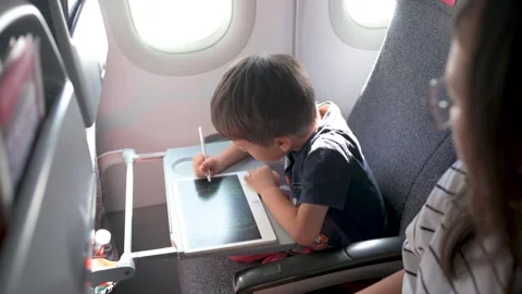 Young boy drawing on tablet during flight Stock-Footage 337788458