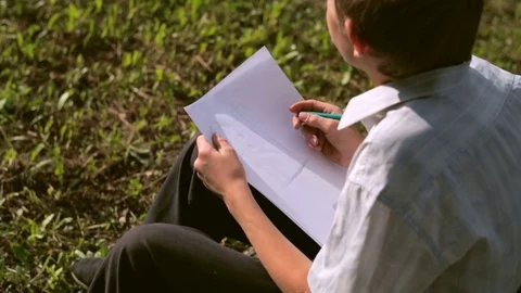 A young boy draws a project on paper Stockbeeldmateriaal 79551978