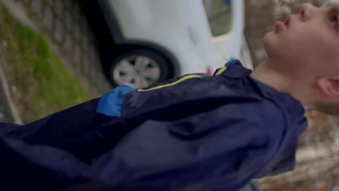 A Young Boy Dressed in a Rain Jacket Joyfully Walking Outdoors in Nature Stock Footage 311206567