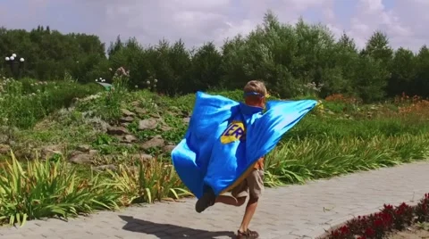 Young boy dressed as superhero playing outdoors Video stock 68175792