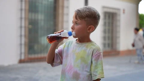 Young Boy Drinking a Bottled Beverage Outdoors 库存影片 341830594