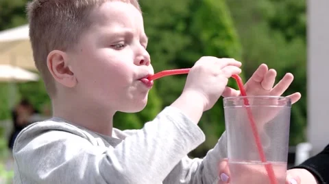 Young Boy Drinking Juice in Cafe Outdoor Stockbeeldmateriaal 62781581