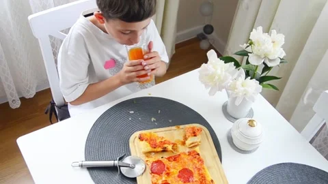 Young boy drinks a glass of orange juice Stock Footage 339578771