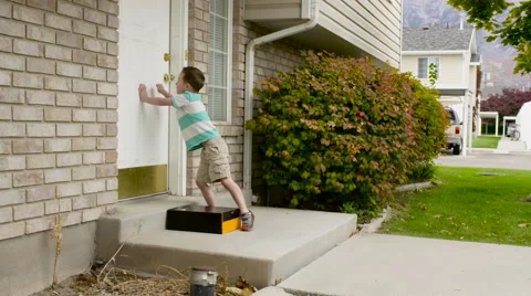 Young boy drops off package on doorstep Stock Footage 62774486