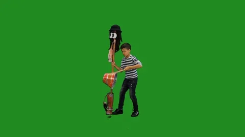 Young boy  drumming on recycled melodic broom stick on  green screen Stock Footage 126279983