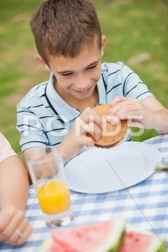 Young boy eating burger with his family Stock Image #32697236