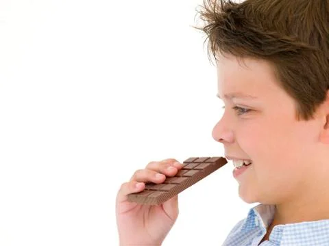Young boy eating chocolate bar Stock Photos