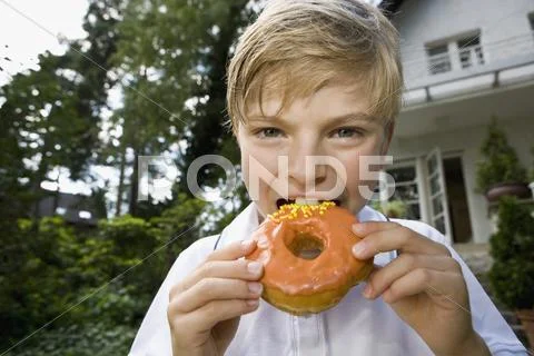 A young boy eating a donut Stock Photos