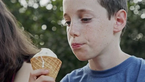 Young boy eating Ice Cream from a cone, enjoying and laughing Video stock 139095341