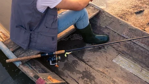 A young boy eats an apple on a wooden boat Stockbeeldmateriaal 81019073