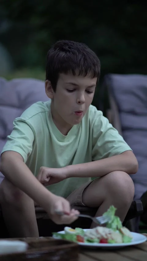 Young boy eats Caesar salad with fork in restaurant 库存影片 342968398