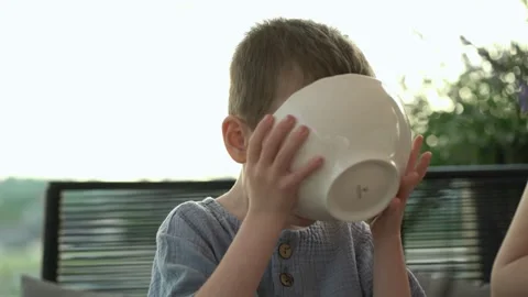 Young boy eats soup on restaurant veranda. Stock Footage 337199092
