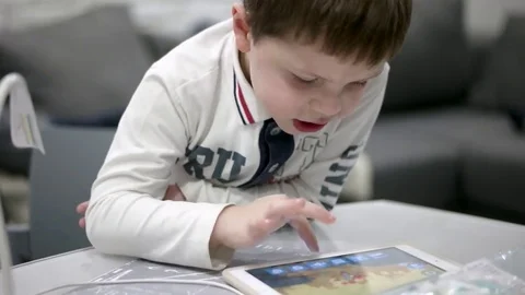 Young Boy Engrossed in Playing Games on His Digital Tablet at Home 動画素材 73669741