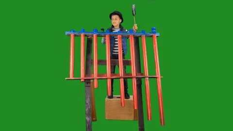Young boy enjoys drumming on recycled melodic tubes in a green screen background Stock Footage