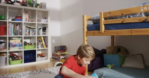 Young boy enthusiastically sits down to play with mobile phone Stock-Footage 101749662