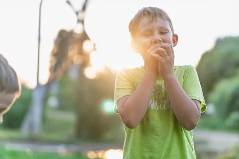 Young boy in evening light with tranquil neighborhood surroundings in village Stock Photos