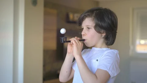 Young boy exercises with deep breathing lung exerciser. Video stock 128057192