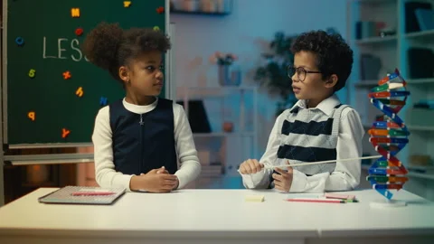 Young boy explaining DNA structure with pointer, showing model to a schoolmate Stock Footage 308000650