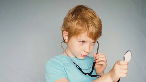 Young boy explores the environment with the help of a stethoscope Vídeo Stock 122257657