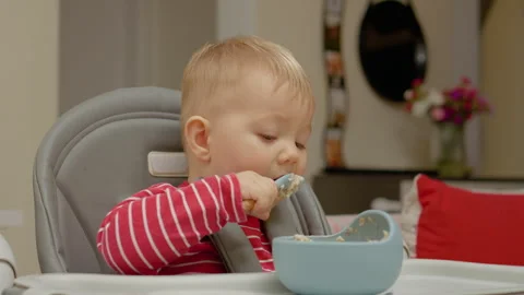 Young boy explores the joy of eating independently during breakfast time Stock Footage 302481837