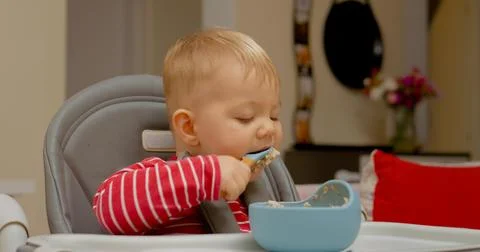 Young boy explores the joy of eating independently during breakfast time Stock Photos