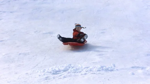 Young boy on fast sled hits pile of snow Stock Footage 62281364