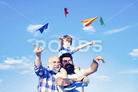 Young boy with father and grandfather enjoying together on blue sky background Stock-Fotos